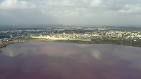 Flying-towards-Aigues-Mortes-cloudy-afternoon,-pink-salt-pond-salin-in-Camargue